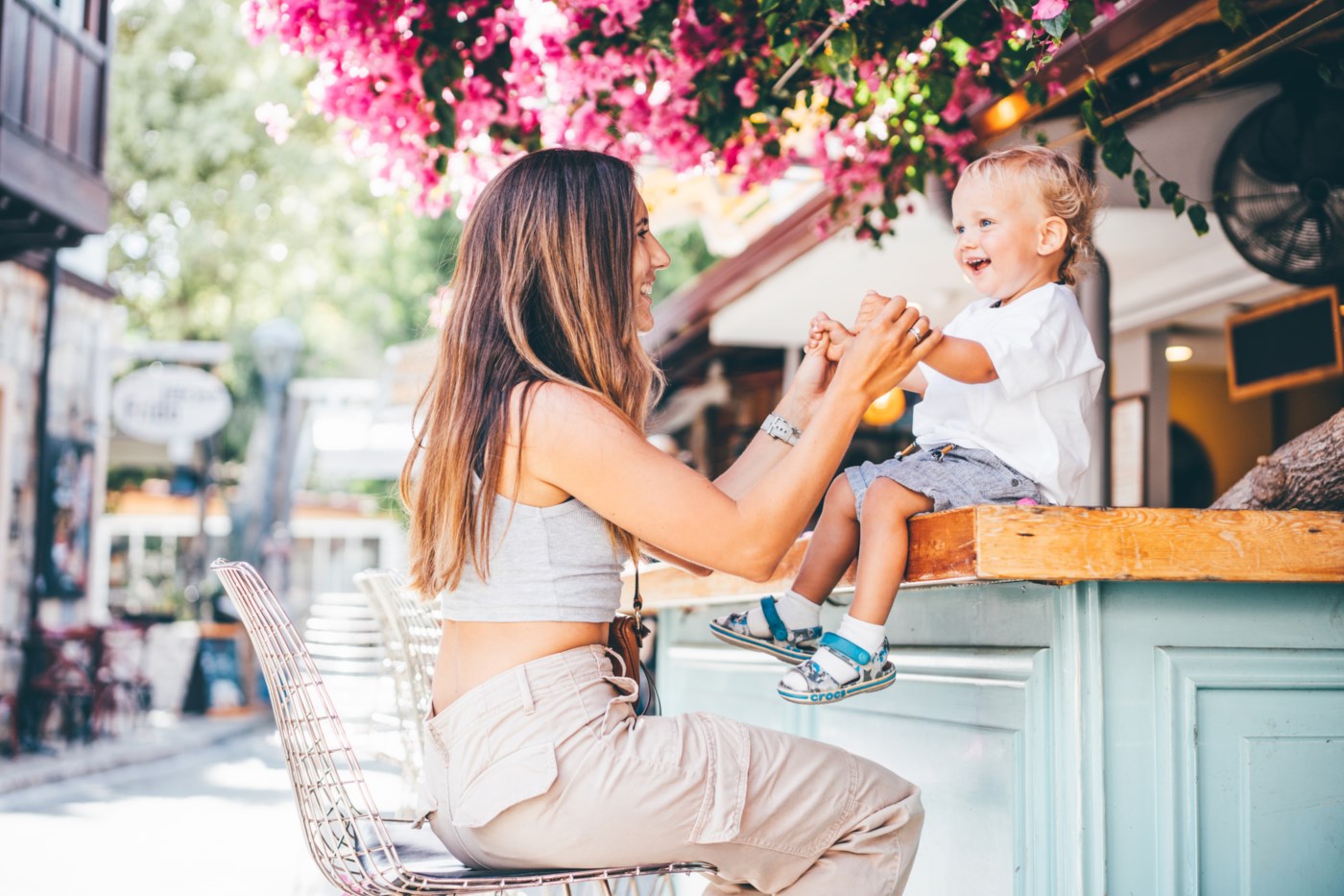 Mor og sønn leker på en cafe, smiler og nyter livet.